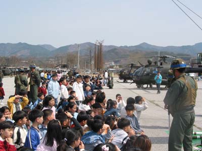 자연 정화 활동 후 초등학교 학생들에게 항공기에 대한 소개를 실시하고 있는 105항공대대 장병들 